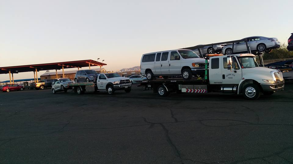 Two Secured Rite Towing flatbeds transporting multiple vehicles
