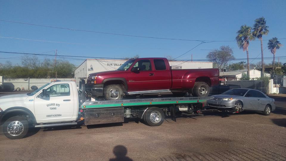 Secured Rite Towing flatbed carrying a red pickup truck